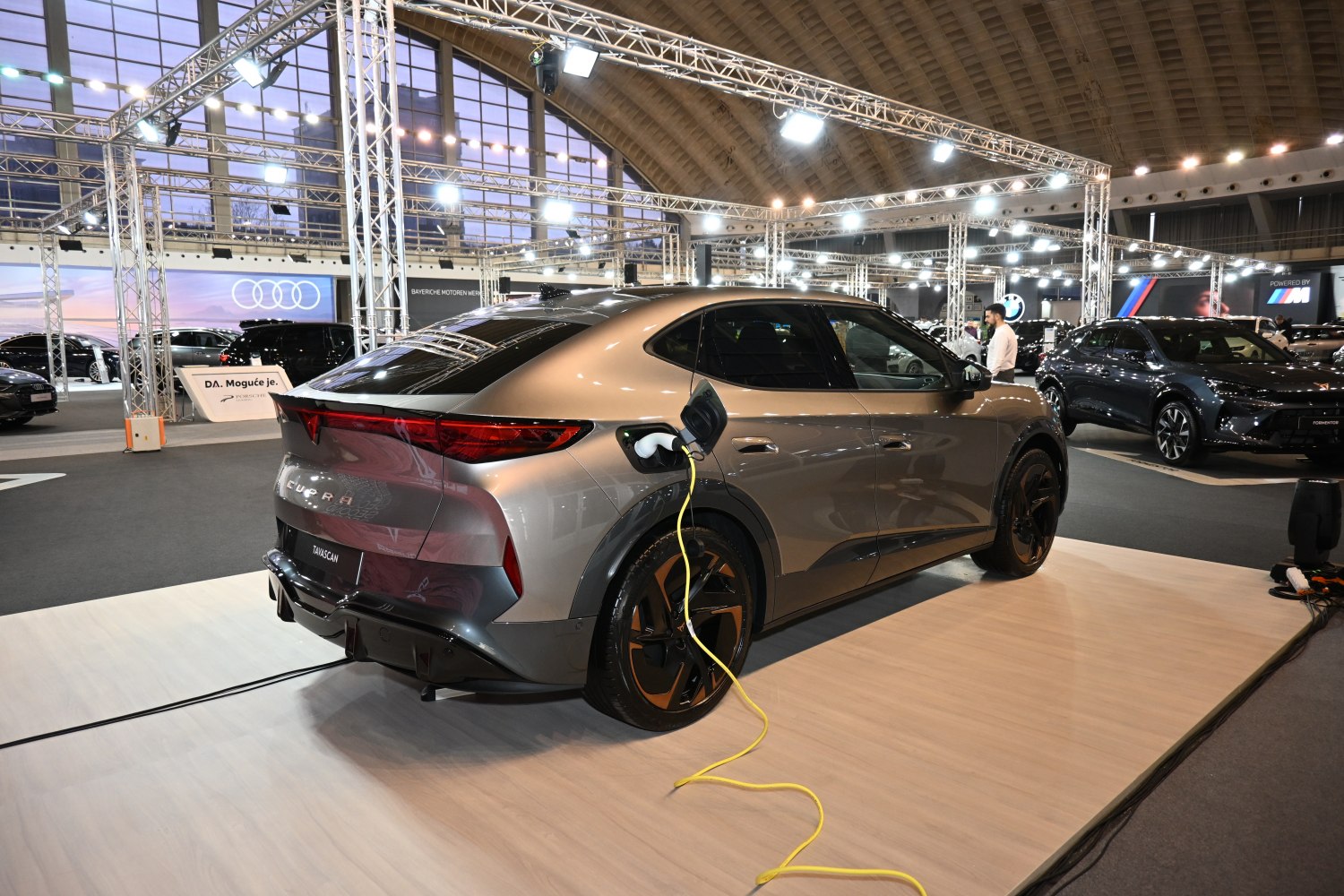 Electric SUV rear with charging plug connected in exhibition