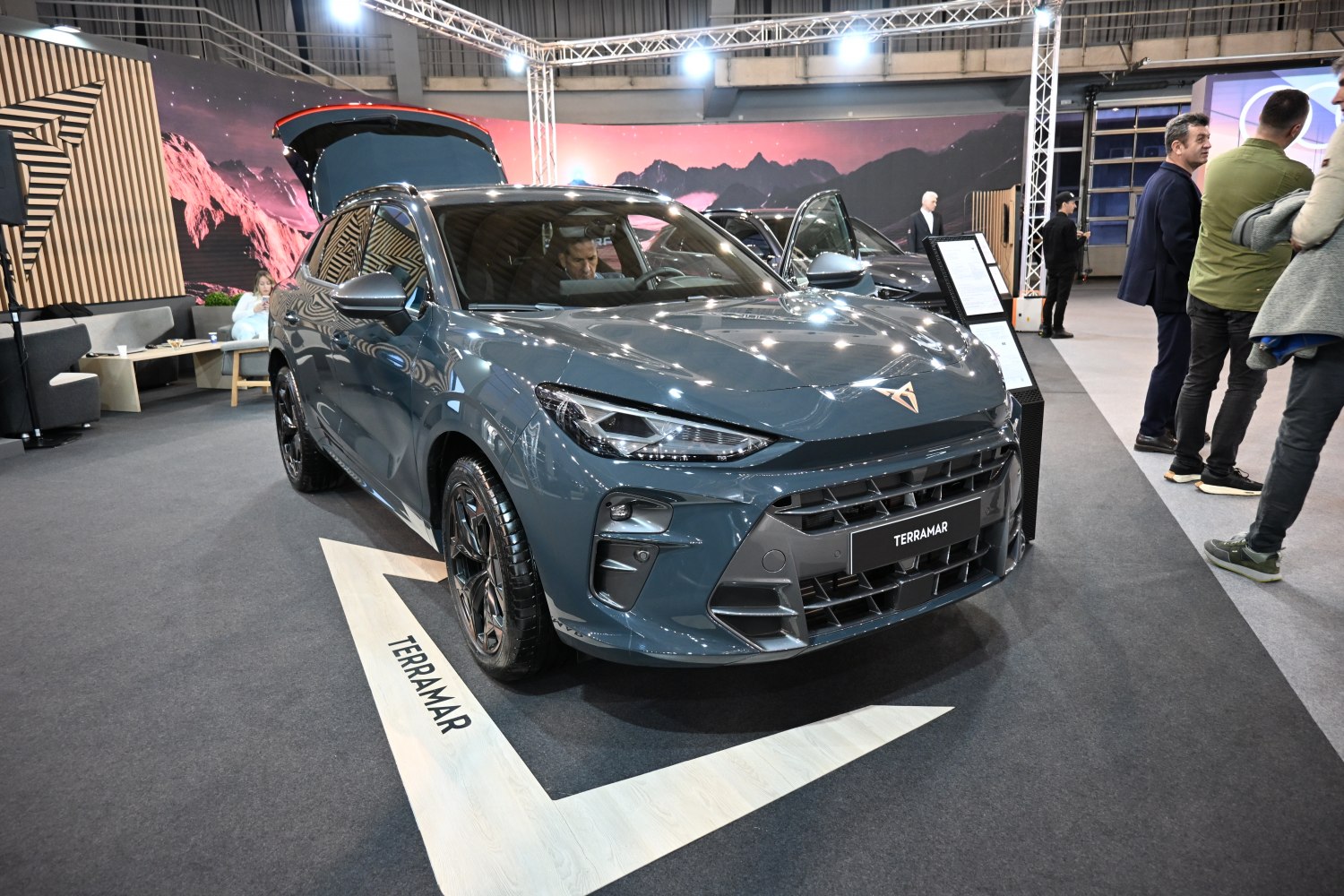 Front view of an SUV with open trunk at an auto show