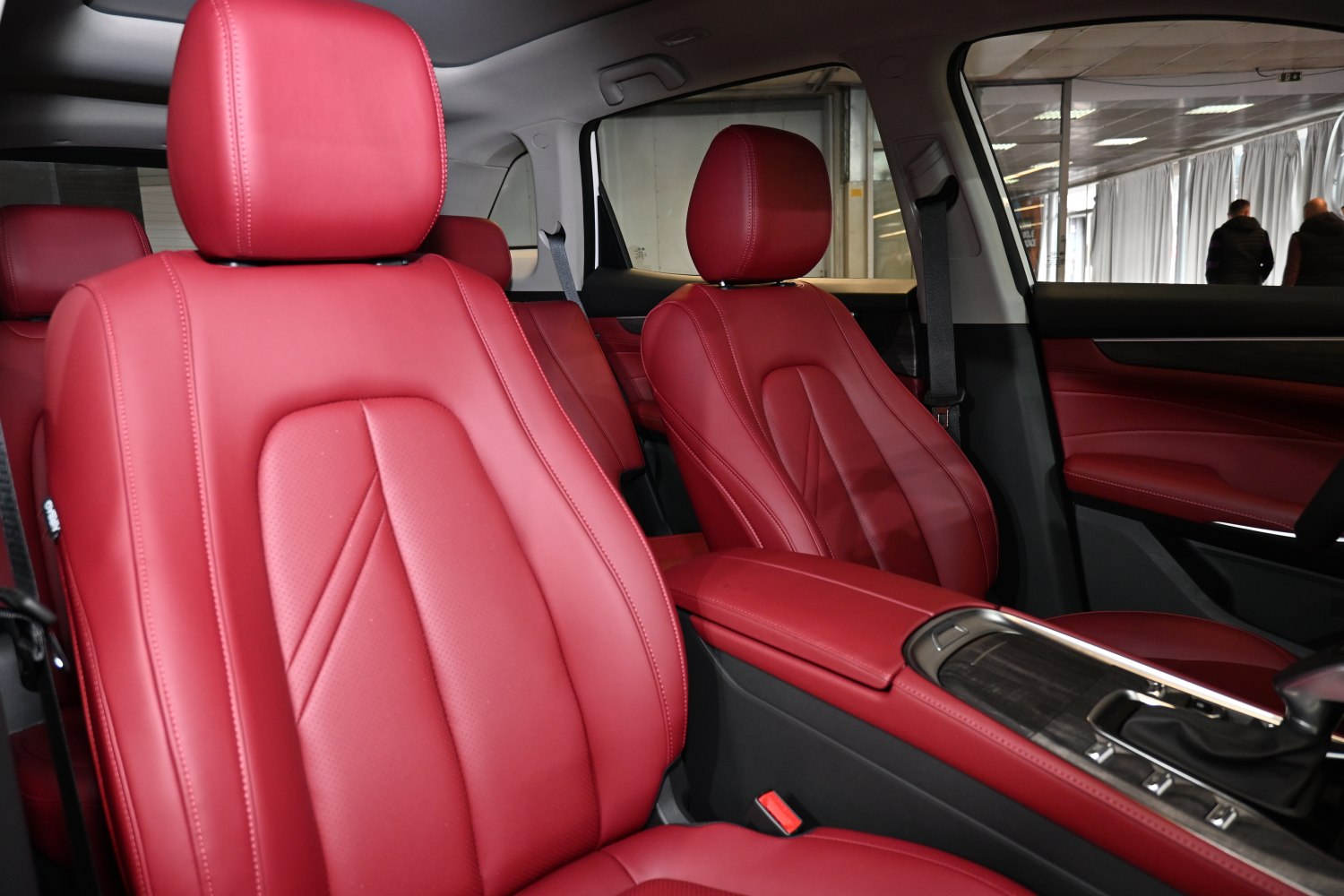 Red leather front seats with detailed stitching and modern design