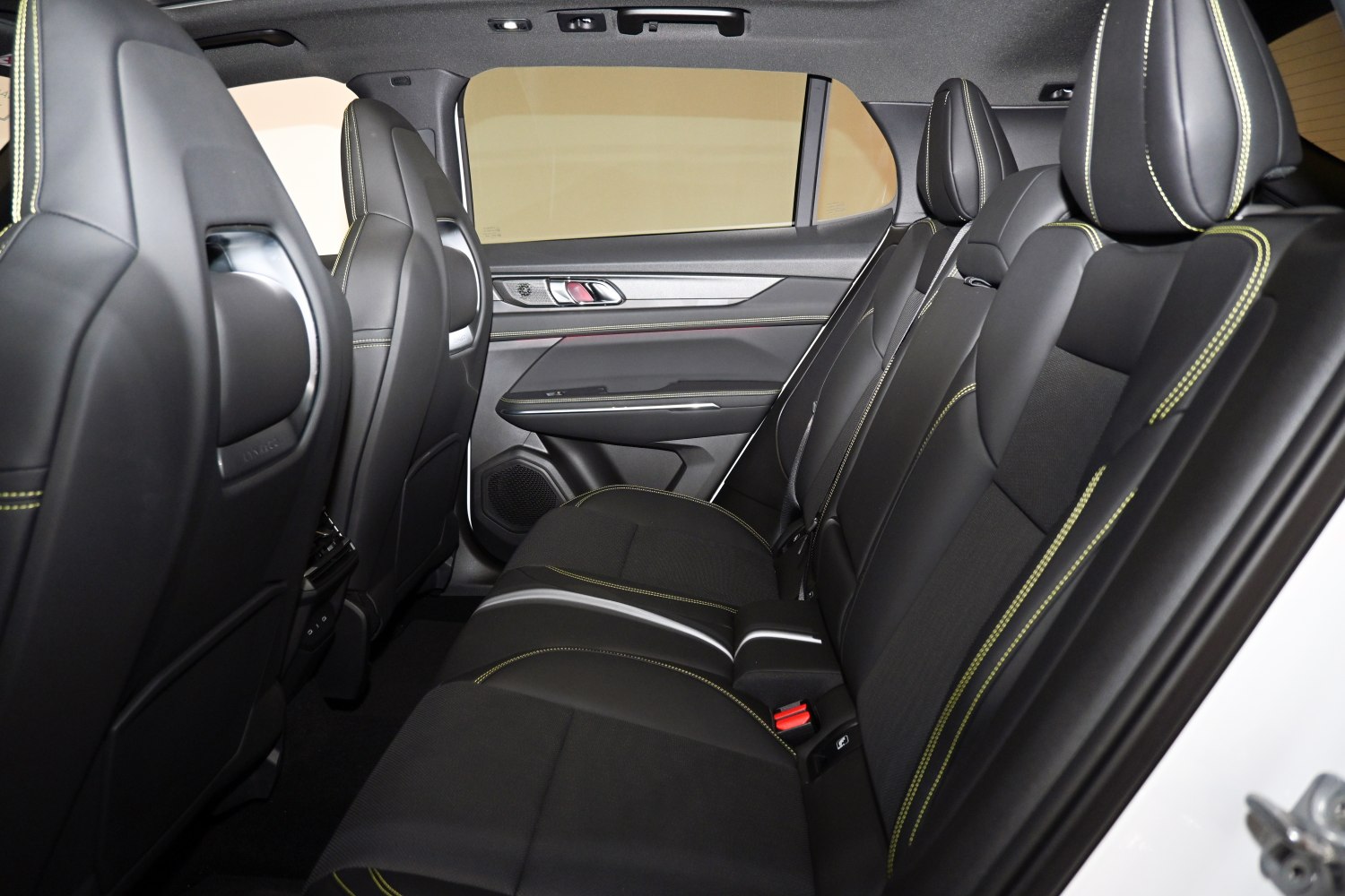 Rear passenger seats in black leather with yellow stitching.