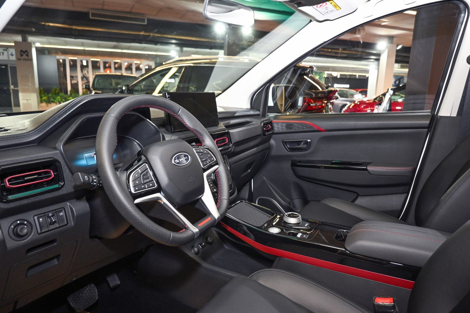 Steering wheel, touchscreen display, and sleek central console with rotary control