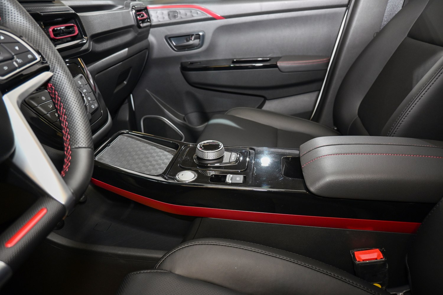 Modern car interior center console with rotary knob and red accents