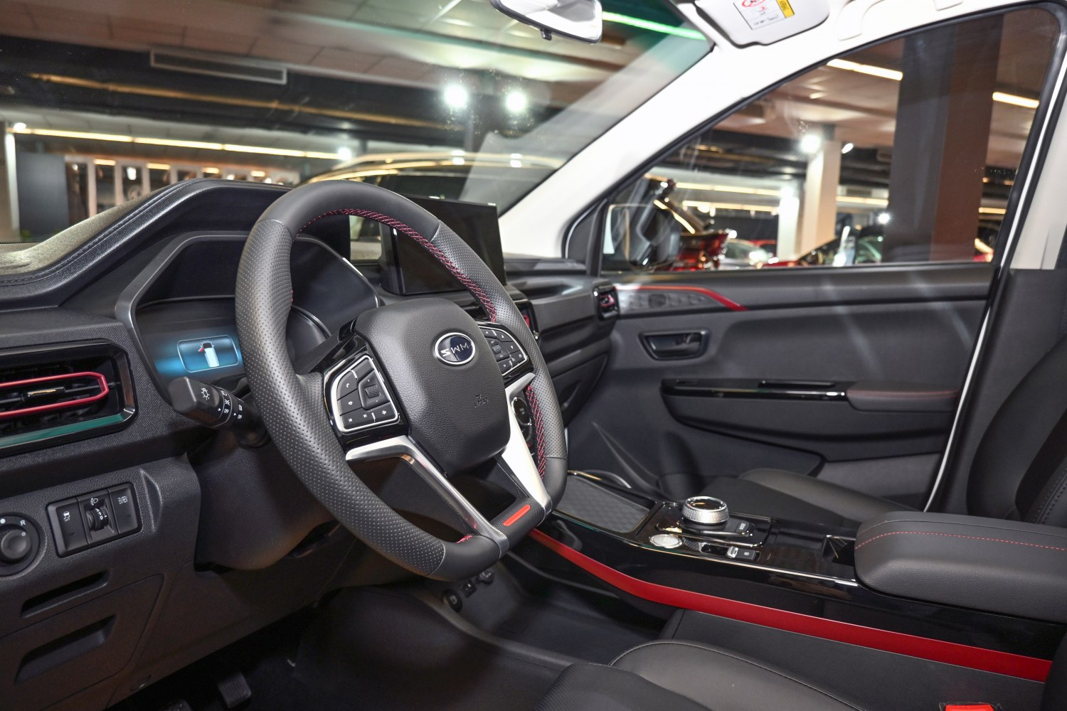 Sporty steering wheel with red stitching and sleek center console with rotary dial