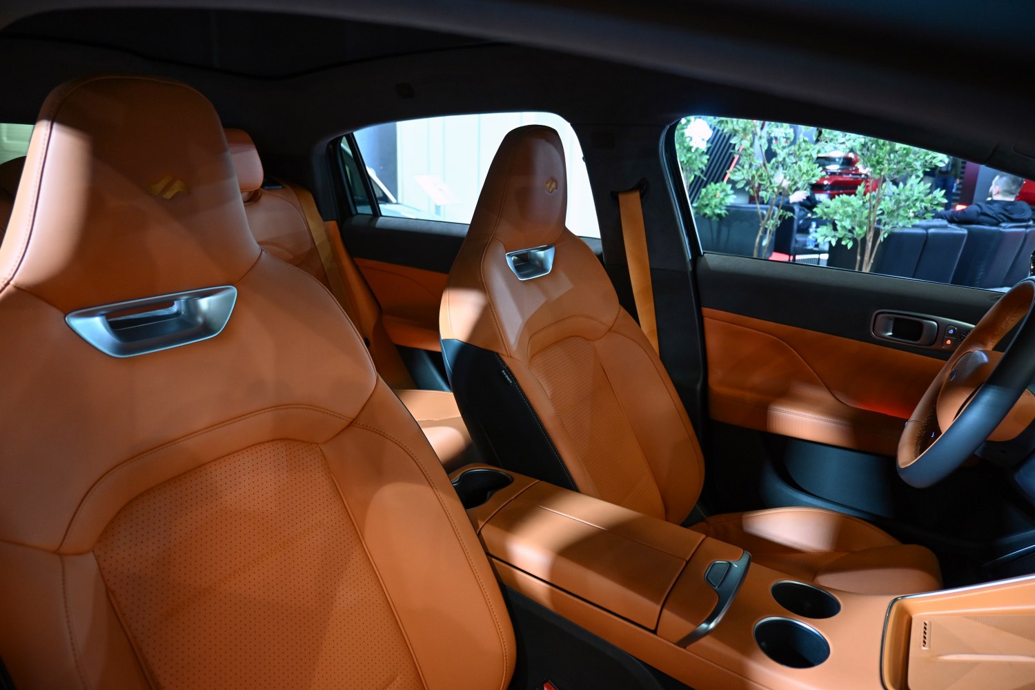 Tan leather bucket seats with perforated design and modern central console.