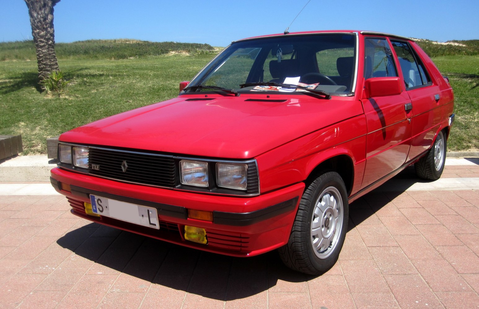 Red hatchback with rectangular headlights and detailed front and wheel design