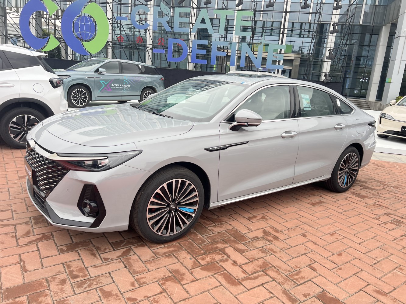 Silver sedan with bold front grille, LED headlights, and detailed alloy wheels