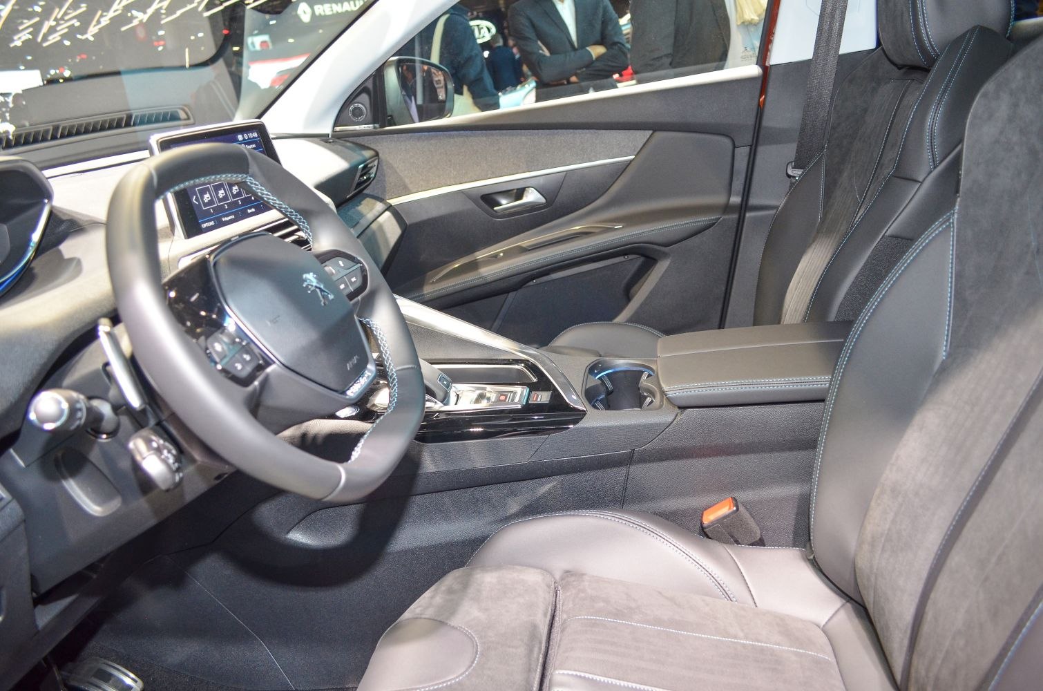 Refined car interior with touchscreen, steering controls, and premium seats.