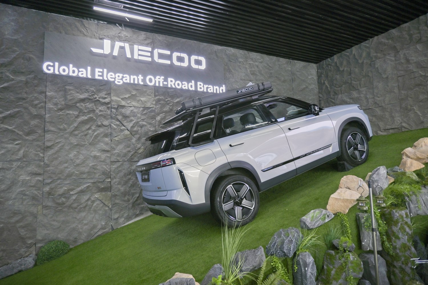 Off-road SUV with roof tent on grassy slope
