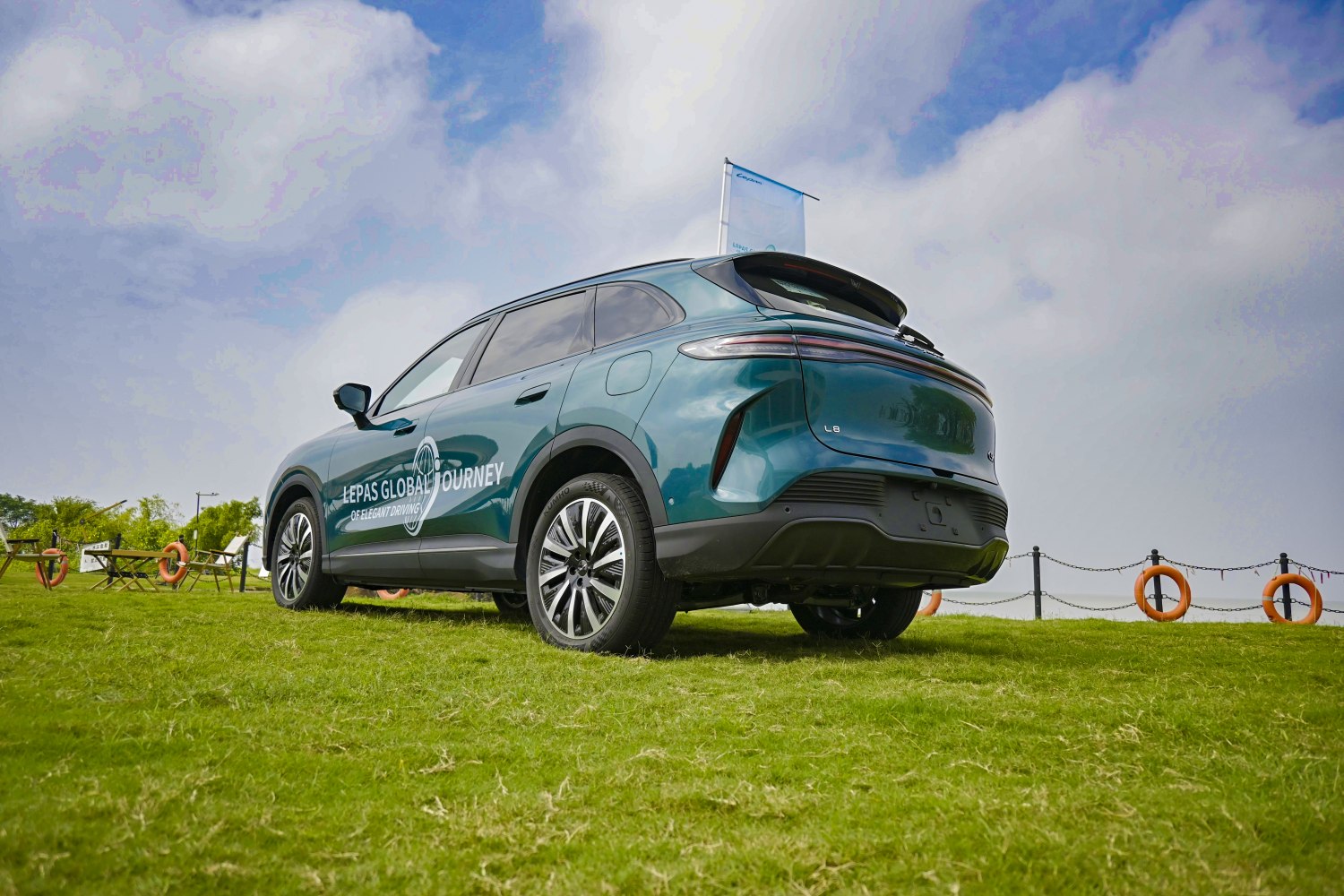 Rear side view of a sporty modern SUV with sleek rims on grass