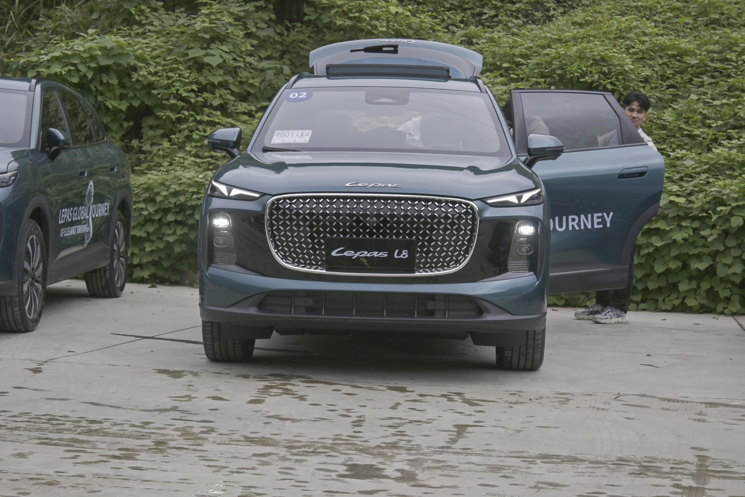 Front view with large geometric grille and slim LED headlights.
