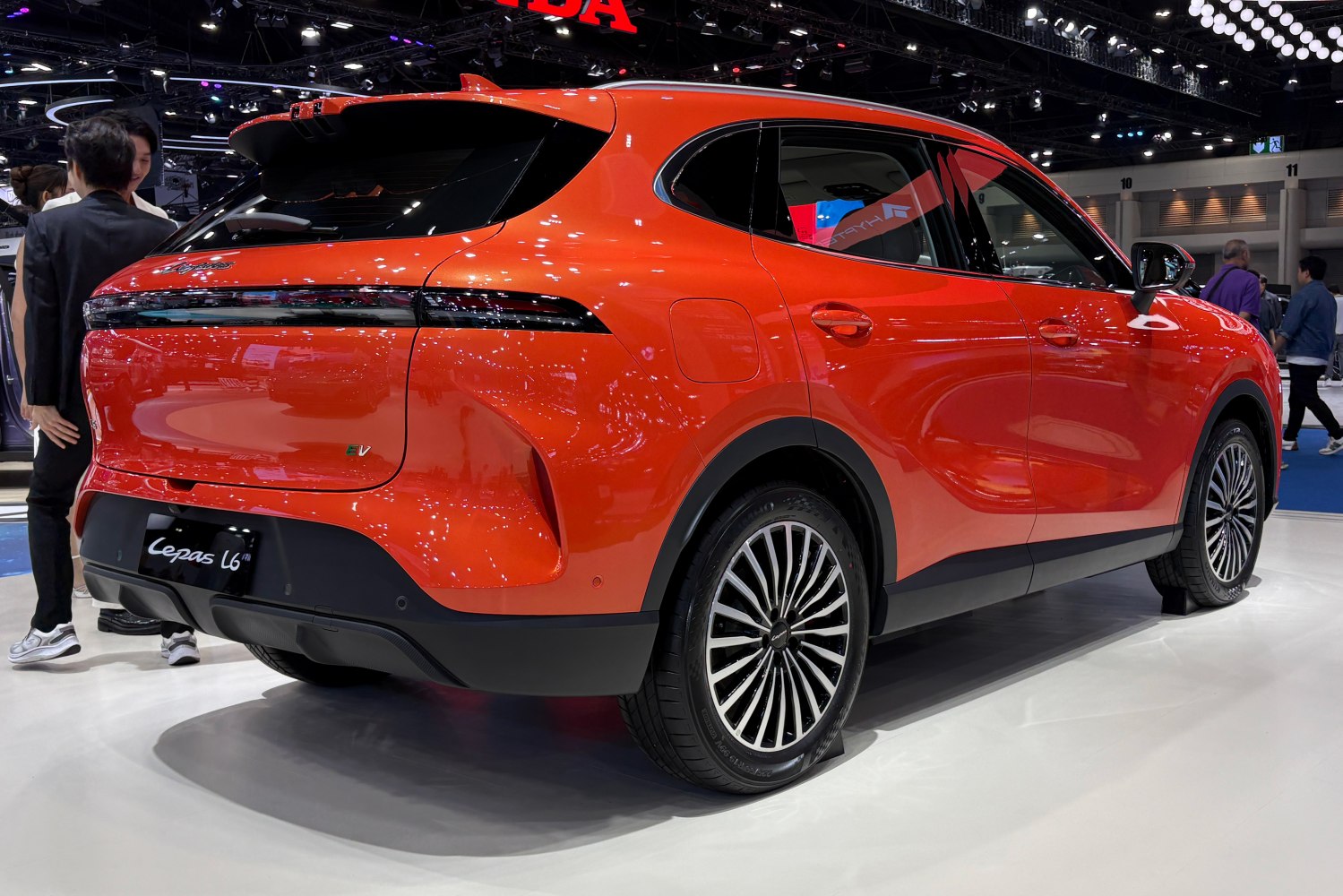 Rear and side view of a sleek red electric SUV with LED taillights and aerodynamic design.