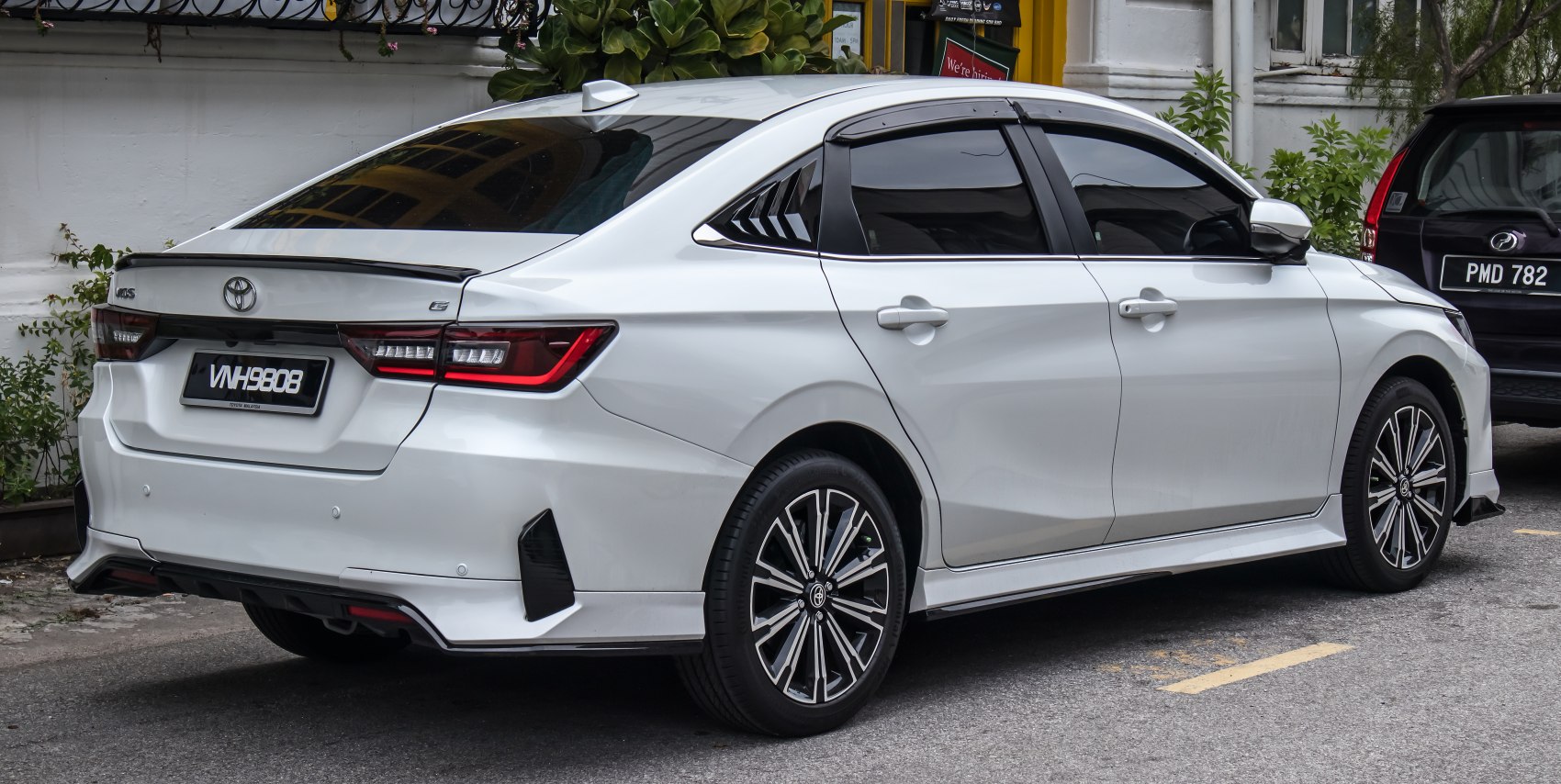 White sedan with rear spoiler and alloy wheels