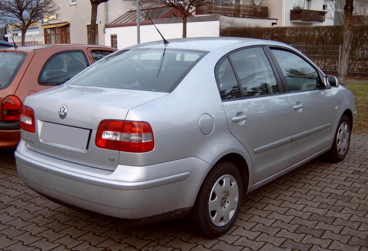 Rear view of a silver four-door sedan with classic tail lights and smooth body lines.