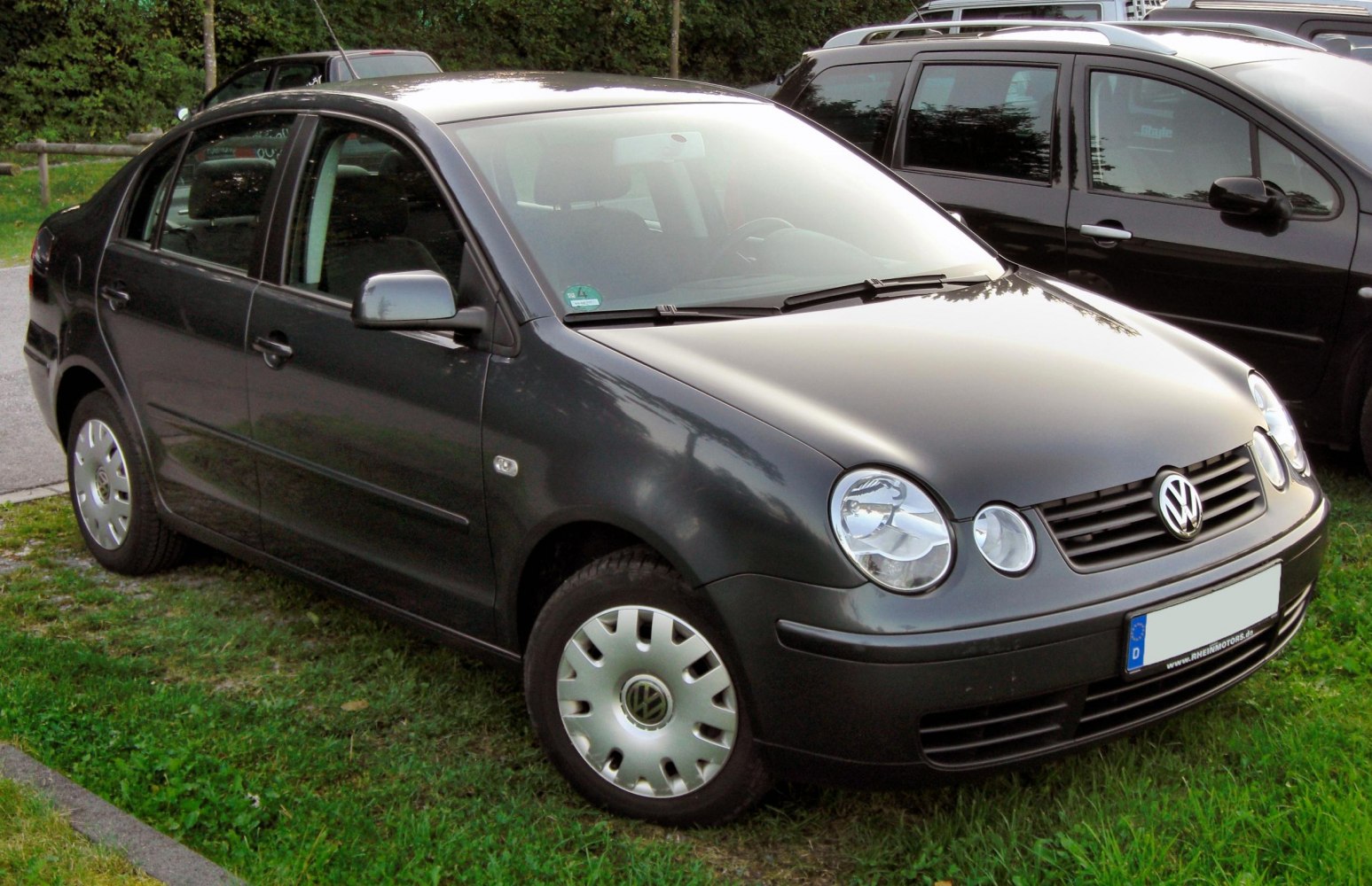 Front side view of compact sedan with rounded headlamps and hubcaps