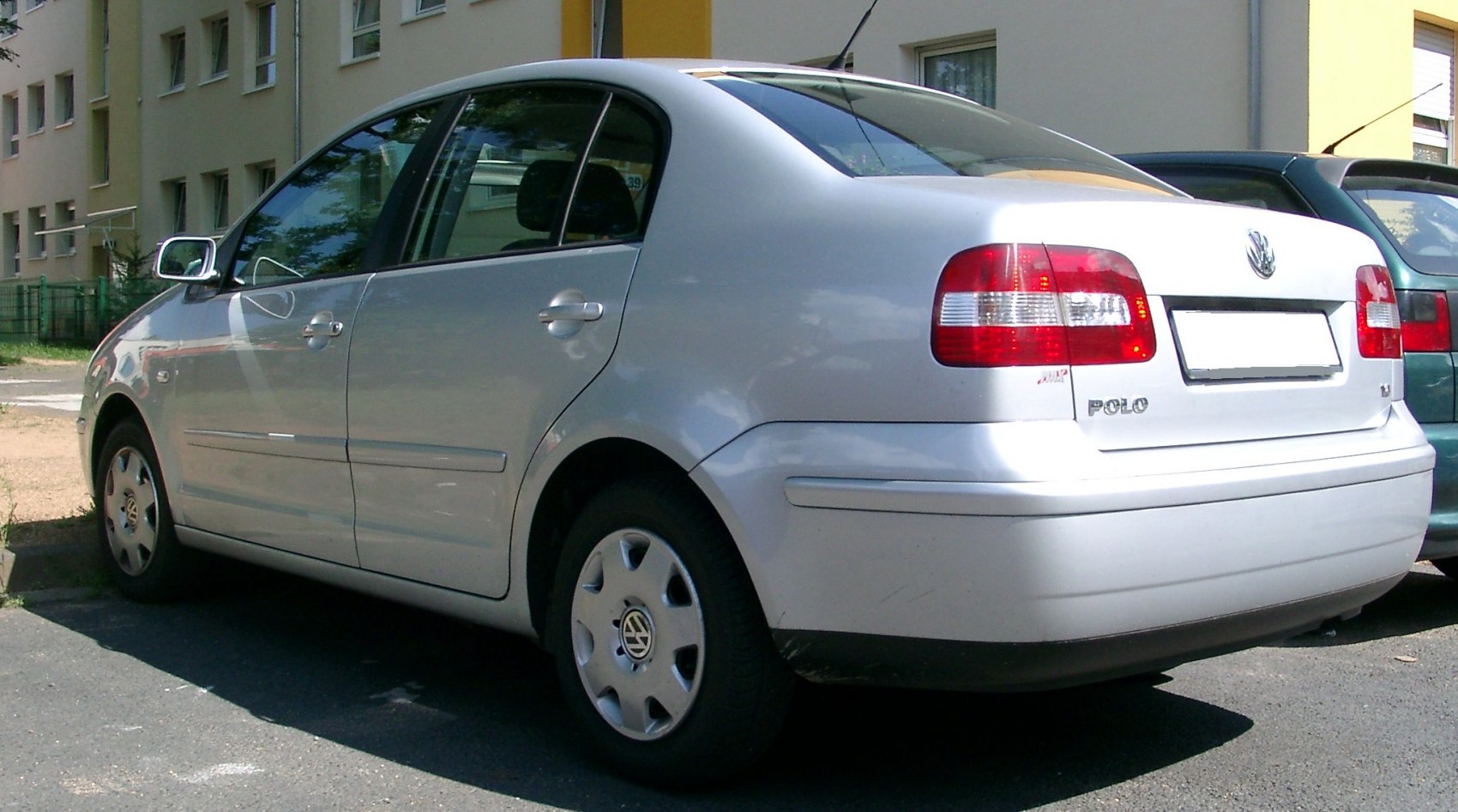 Rear side view of a silver sedan with distinctive taillights and rounded design