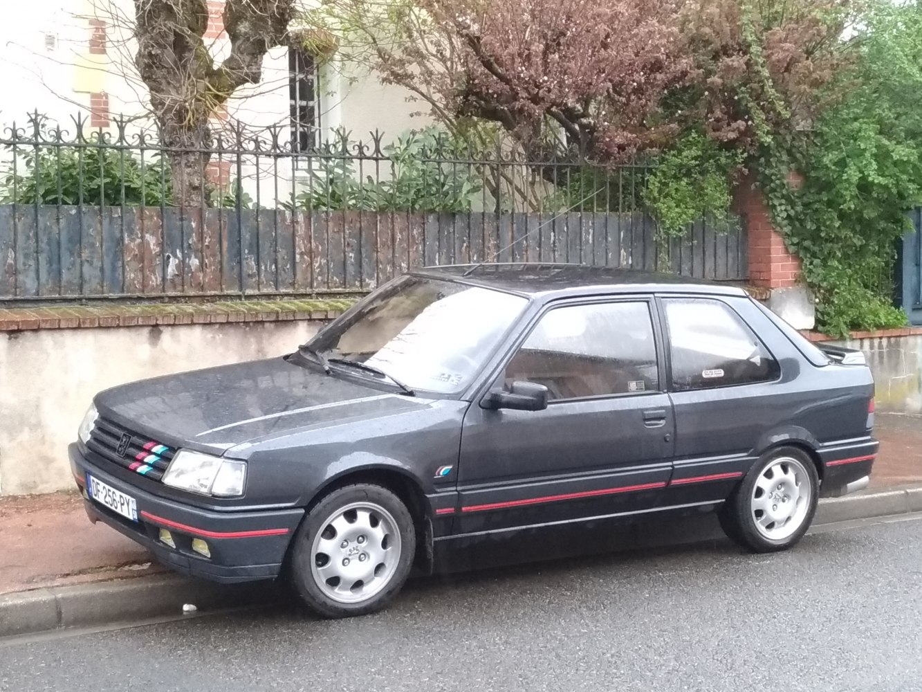 3-door hatchback with alloy wheels, sporty red trim, and rear spoiler