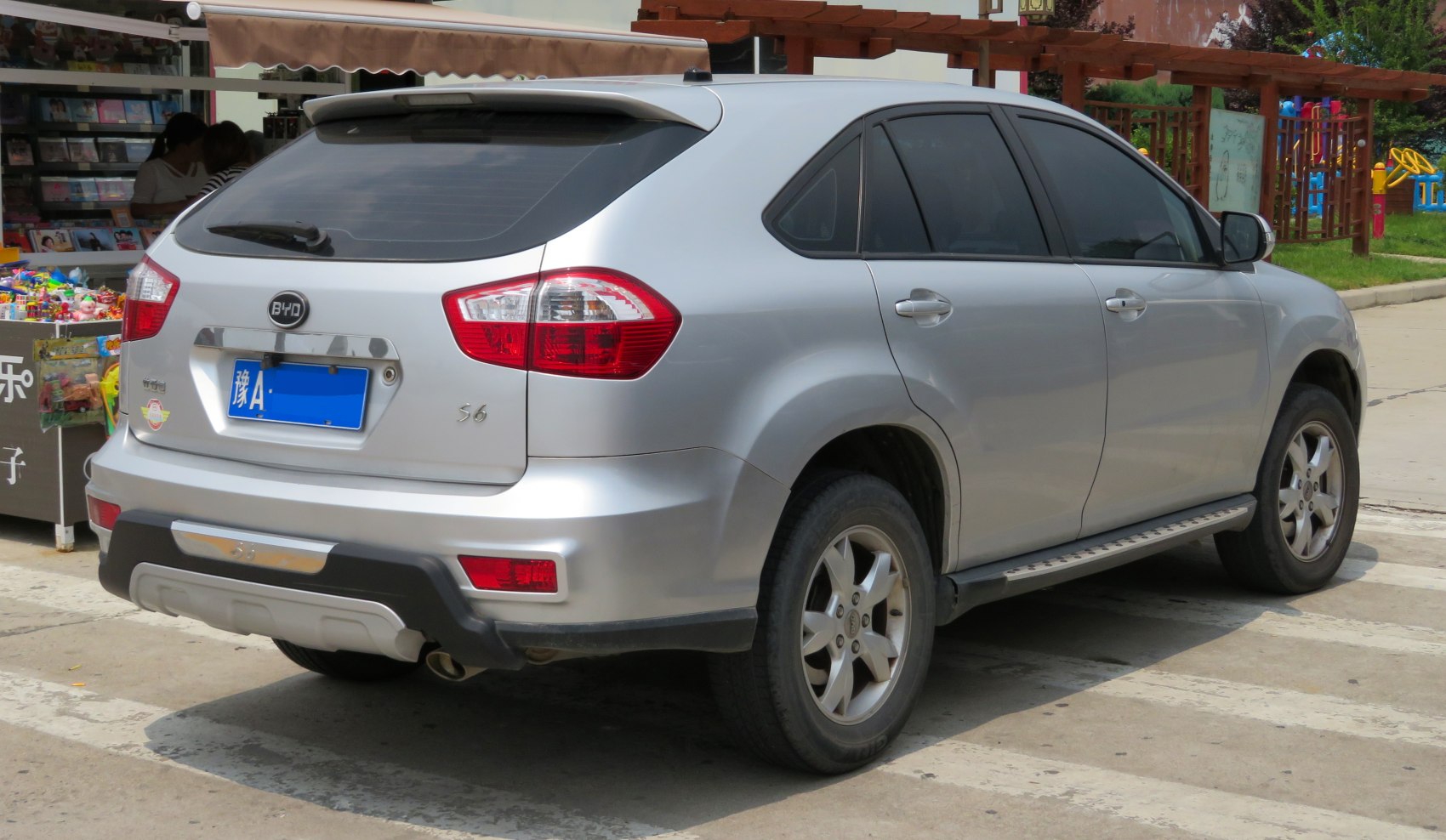 Rear side view of silver SUV with tinted windows and rear spoiler