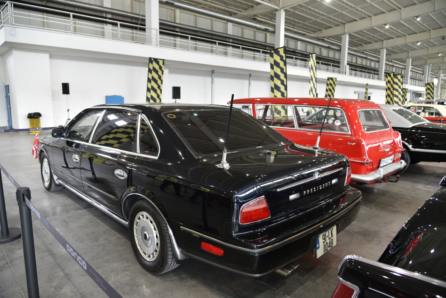Rear and side view of a classic luxury sedan with dual antennas