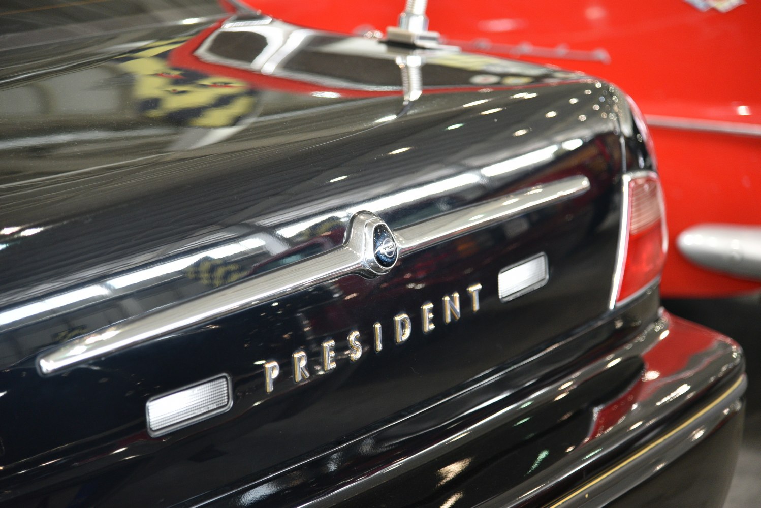 Close-up of a car trunk with emblem and President lettering