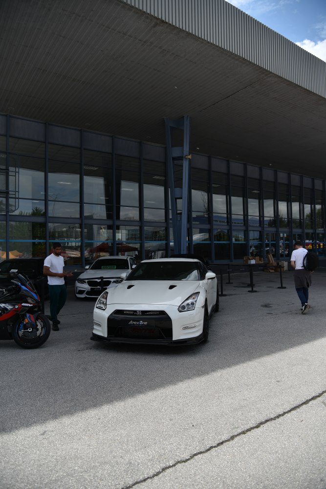 Front view of white sports car with aggressive grille and hood vents