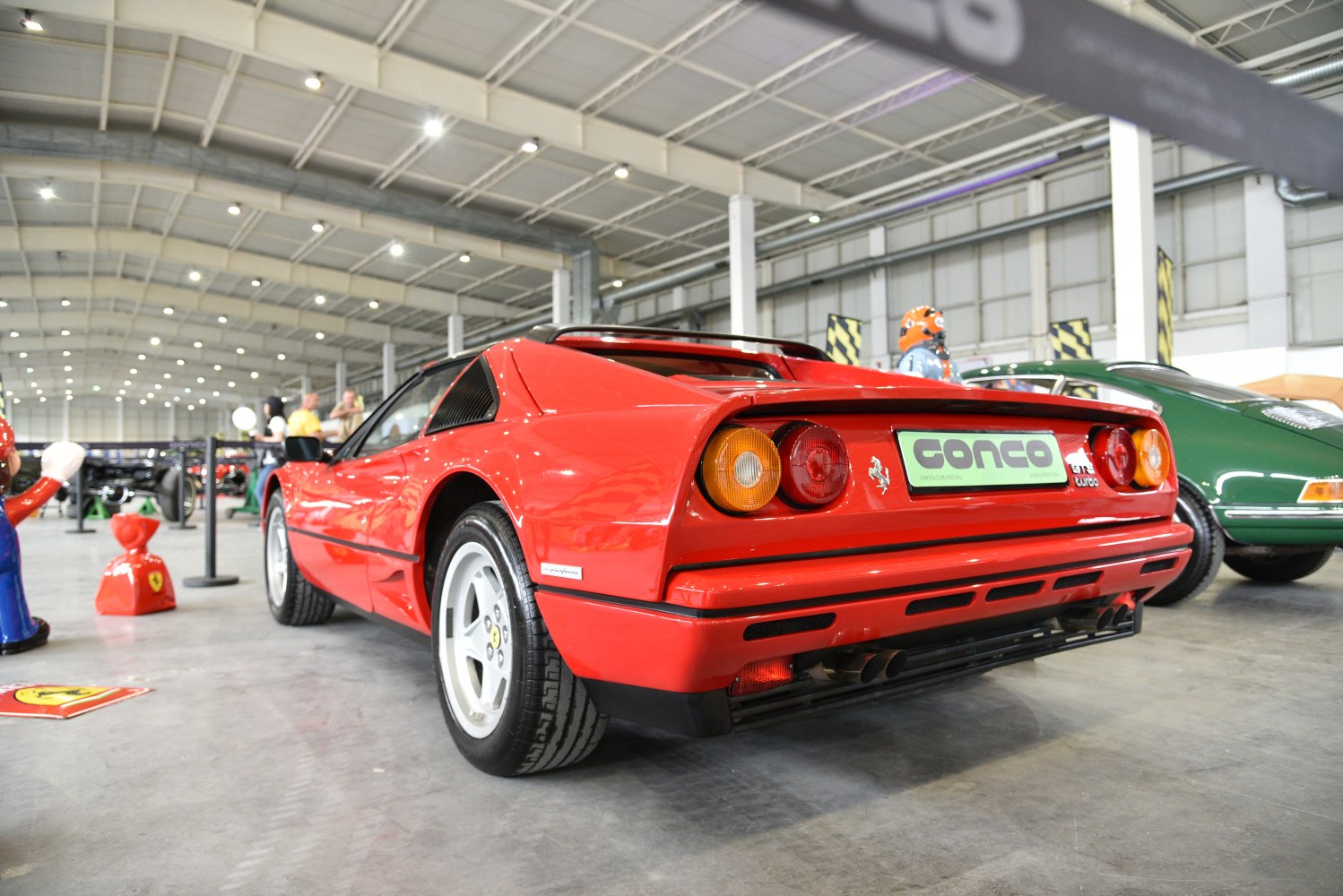 Red vintage sports car rear with round taillights and dual exhaust