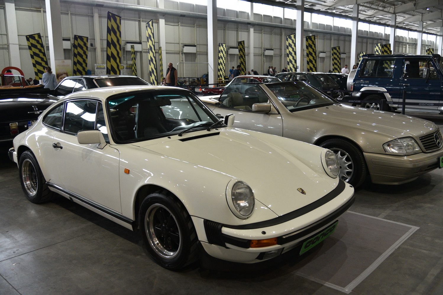 Vintage white sports coupe with round headlights and black alloy wheels.