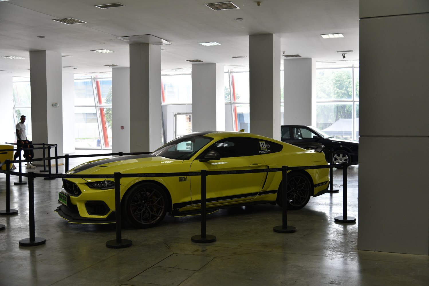 Yellow muscle coupe with black racing stripes and aggressive styling