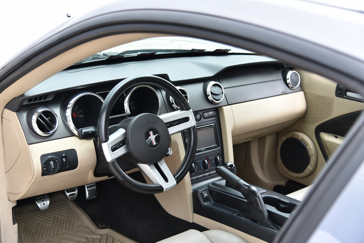 Sporty steering wheel, analog gauges, beige dashboard interior