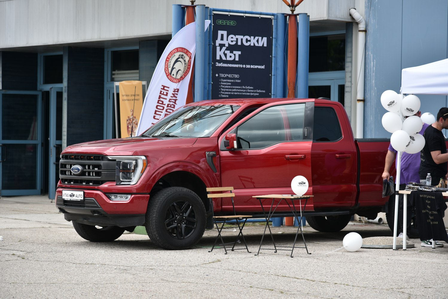 Red modern pickup truck front-side with black wheels and grille
