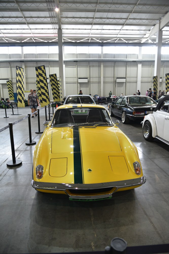 Yellow sports car with central dark racing stripe front view