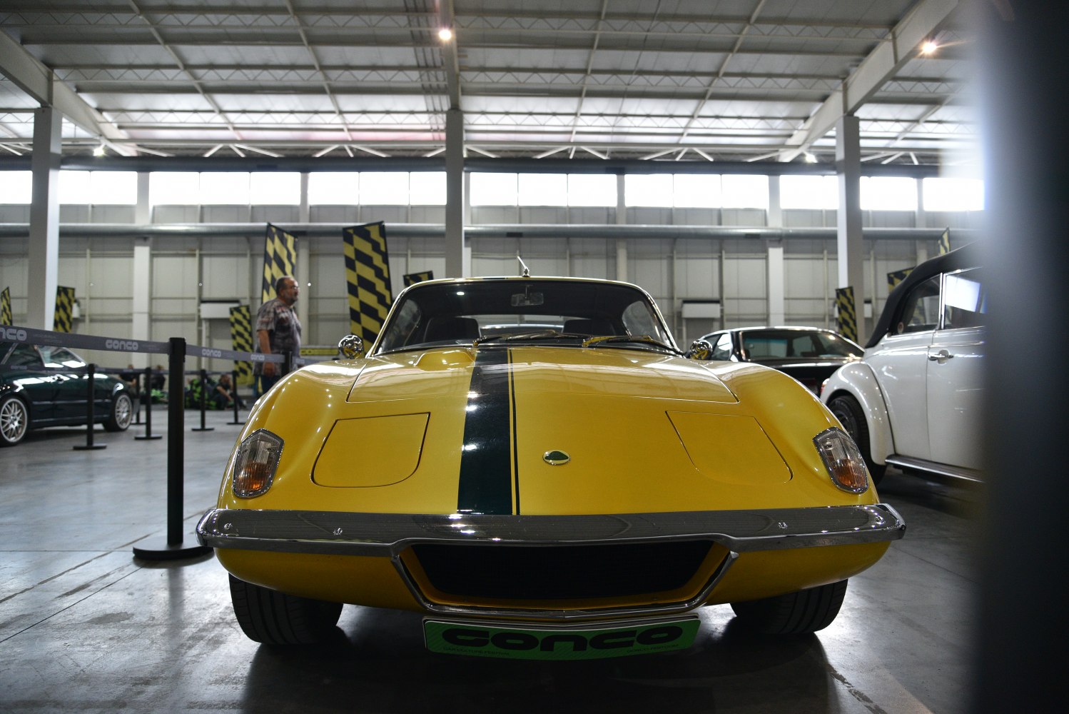 Front view of yellow classic sports car with central racing stripe