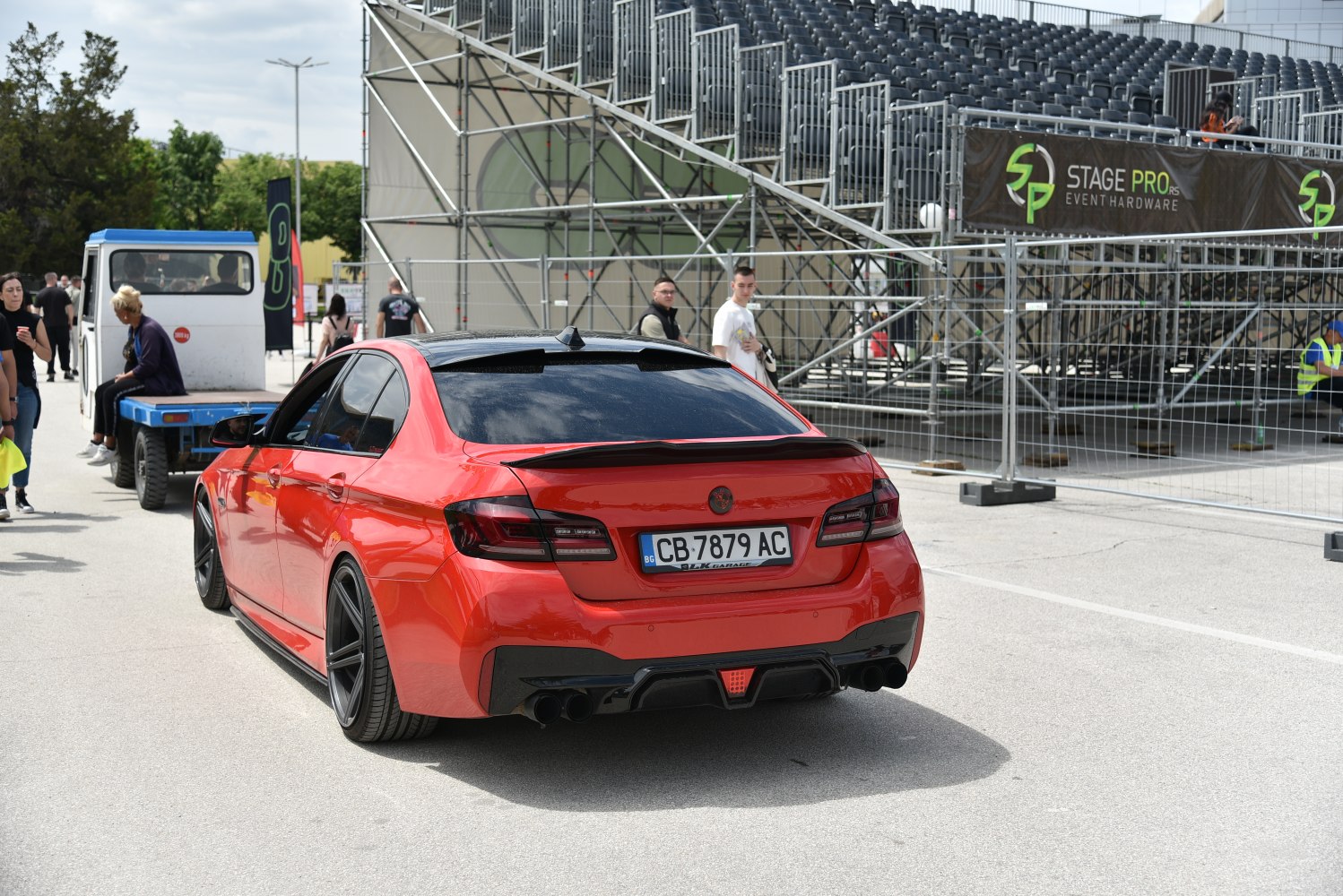 Red sedan rear with black tail lights and quad exhaust