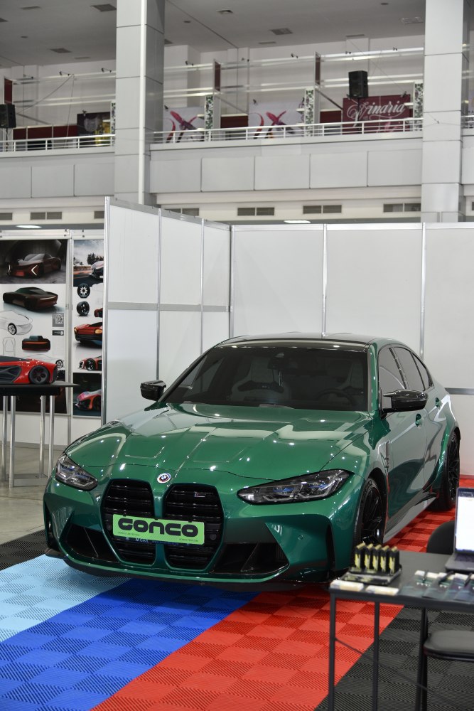 Front view of green BMW M3 G80 with large kidney grille and sleek headlights