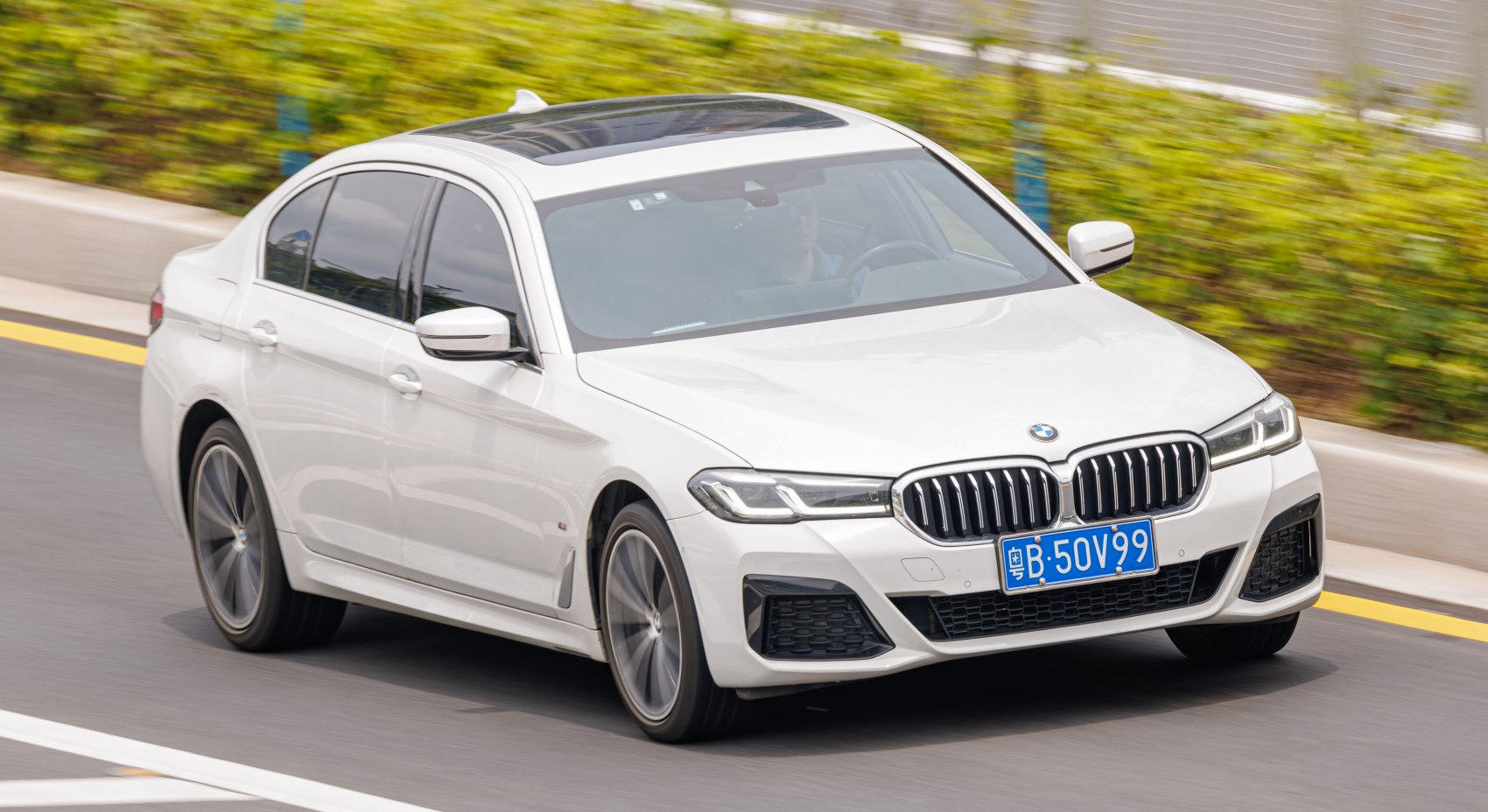 Front angle of a white luxury sedan with LED headlights and kidney grille