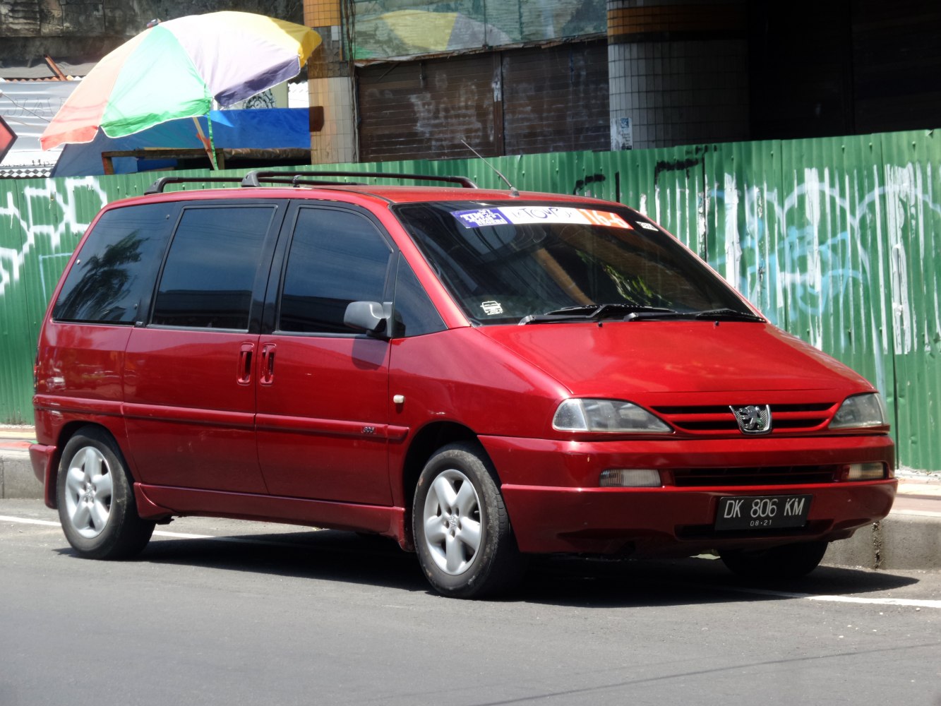 Red minivan with sliding side doors and roof rails.