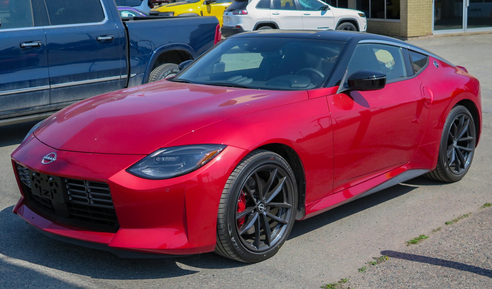 Red sport coupe front-side view with sleek headlights and black alloy wheels