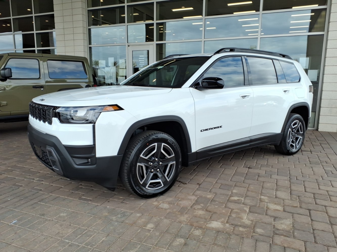Front and side profile of a white SUV with sleek headlights and alloy wheels