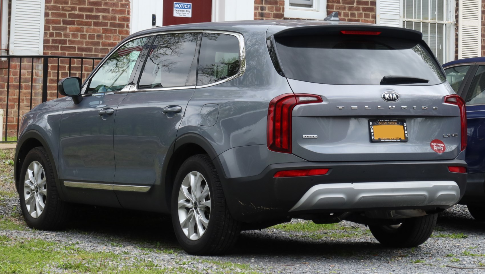 Rear side view of SUV with vertical tail lights and chrome window trim