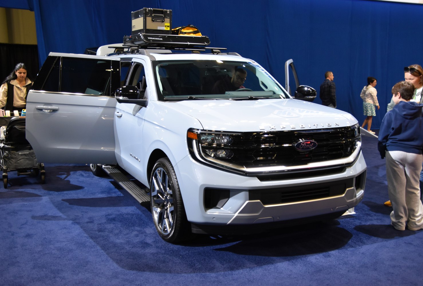 Full-size SUV with roof rack gear and open side doors