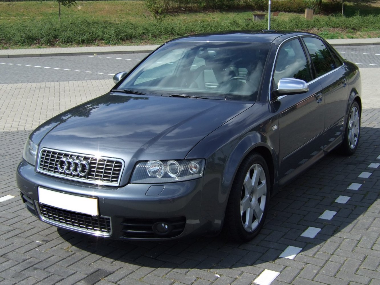 Front side view of a sedan with alloy wheels and dual round headlights
