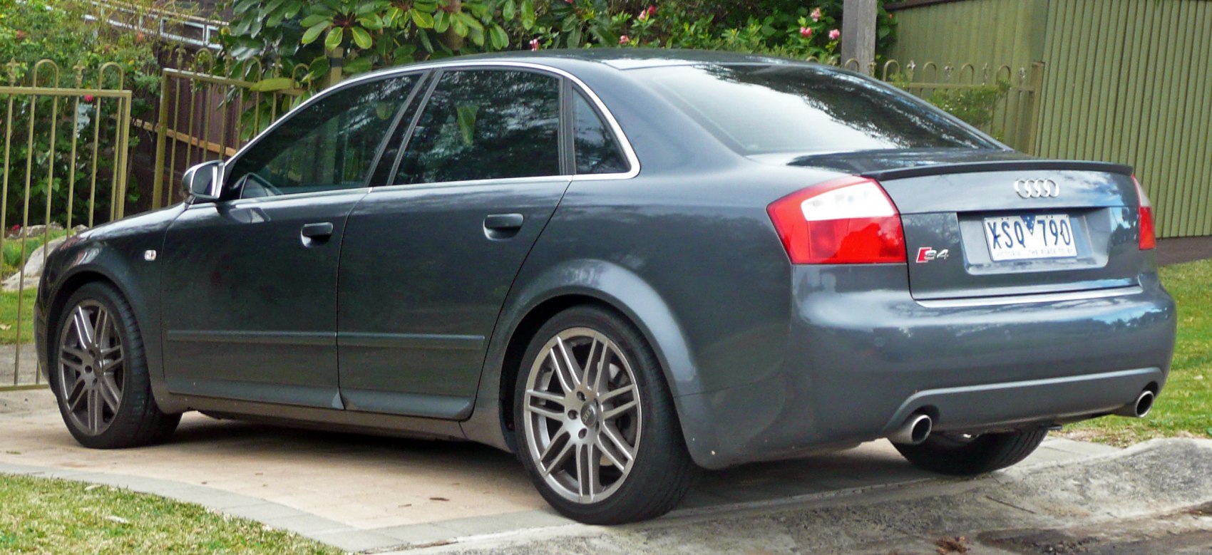 Rear and side view of sedan with alloy wheels and dual exhaust