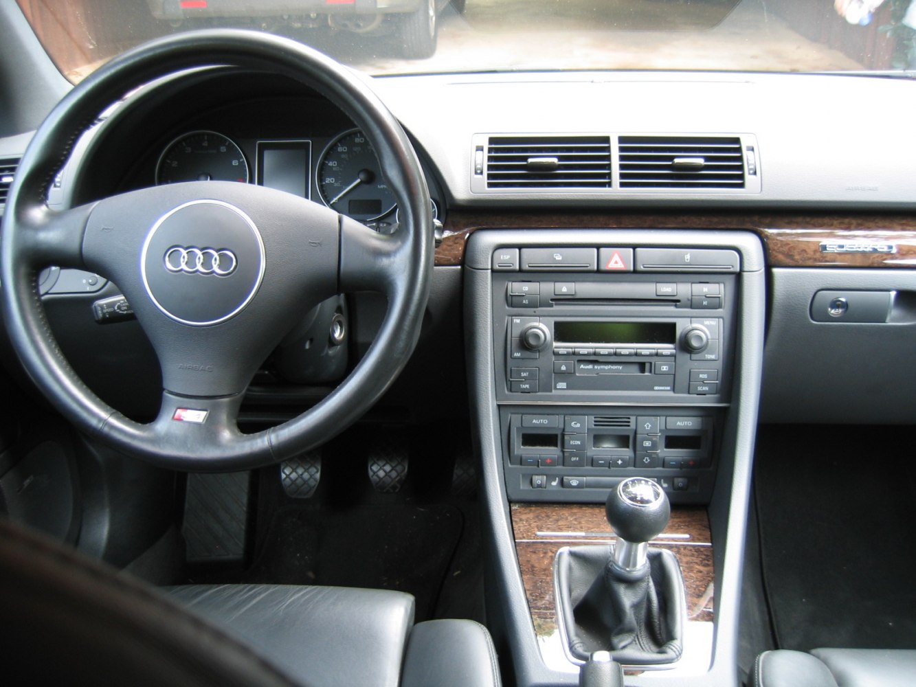 Dashboard with instrument cluster, wood trim, and manual transmission gearstick