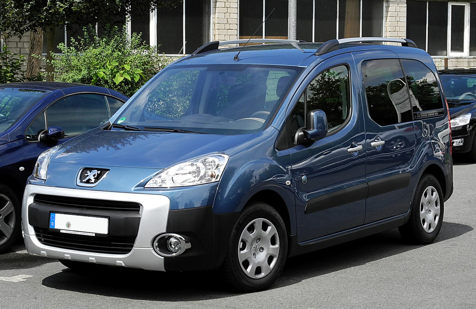 Blue compact MPV with roof rails and alloy wheels