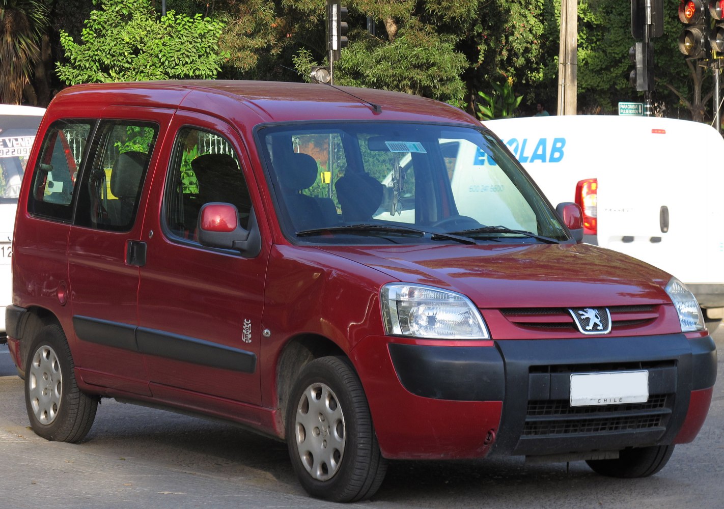 Red compact multi-purpose vehicle with sliding door and rectangular headlights.