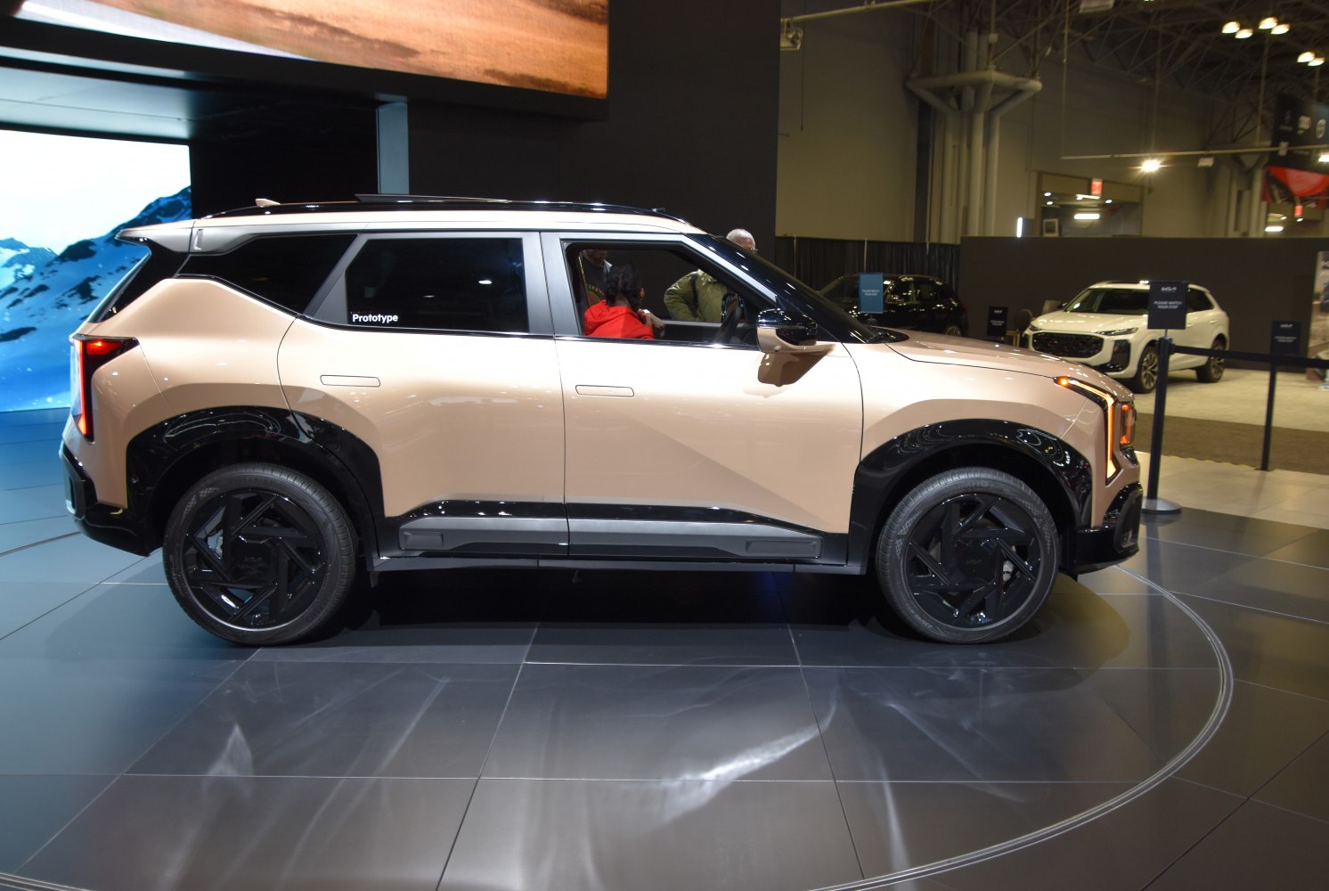 Side profile of a futuristic prototype SUV with black wheel arches and sleek multi-spoke wheels