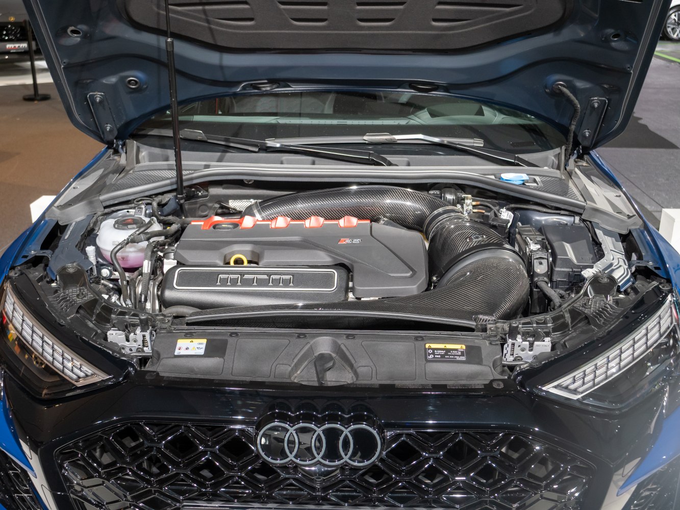 Close-up of engine bay with intake system and modern engine cover.