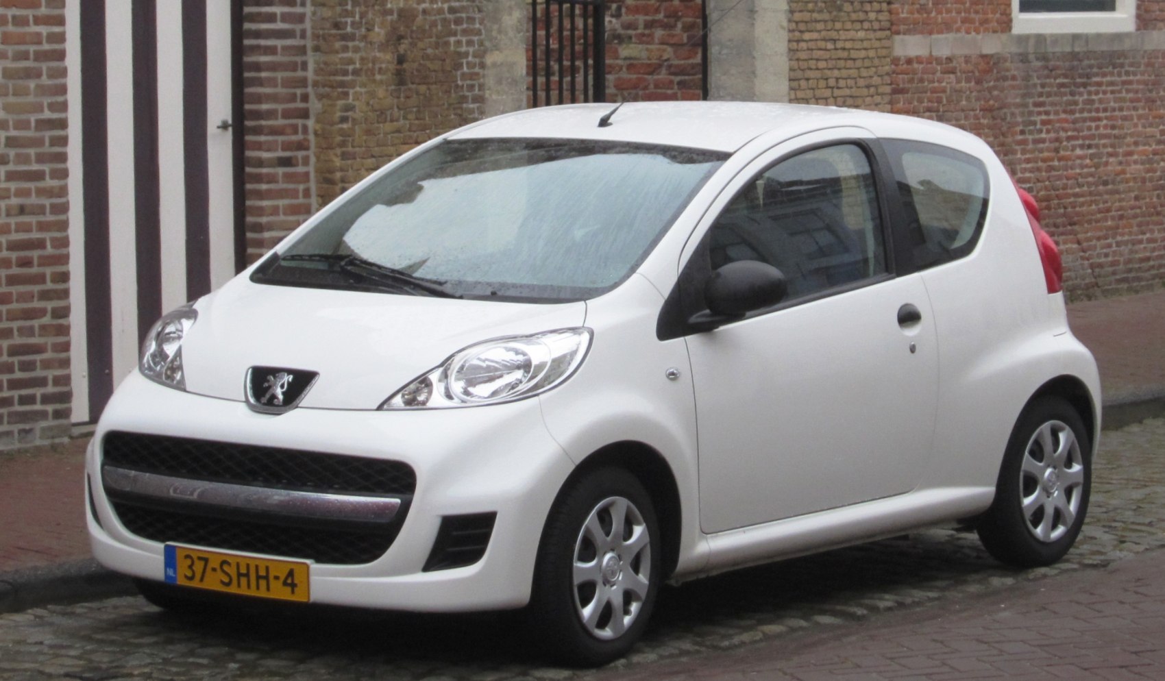 Front-side view of a white compact 3-door hatchback with smooth aerodynamic design.