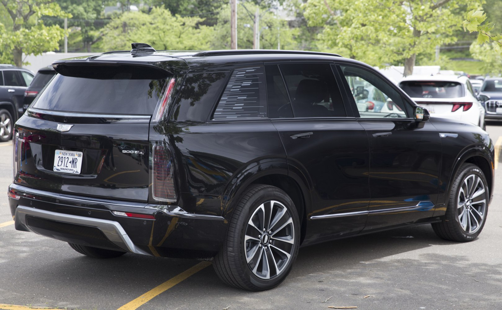 Rear view of a black electric SUV with vertical LED tail lights and alloy wheels.