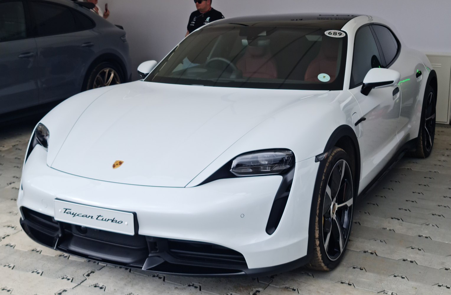 Front view of a white electric sports sedan with sleek aerodynamic design and modern headlights.