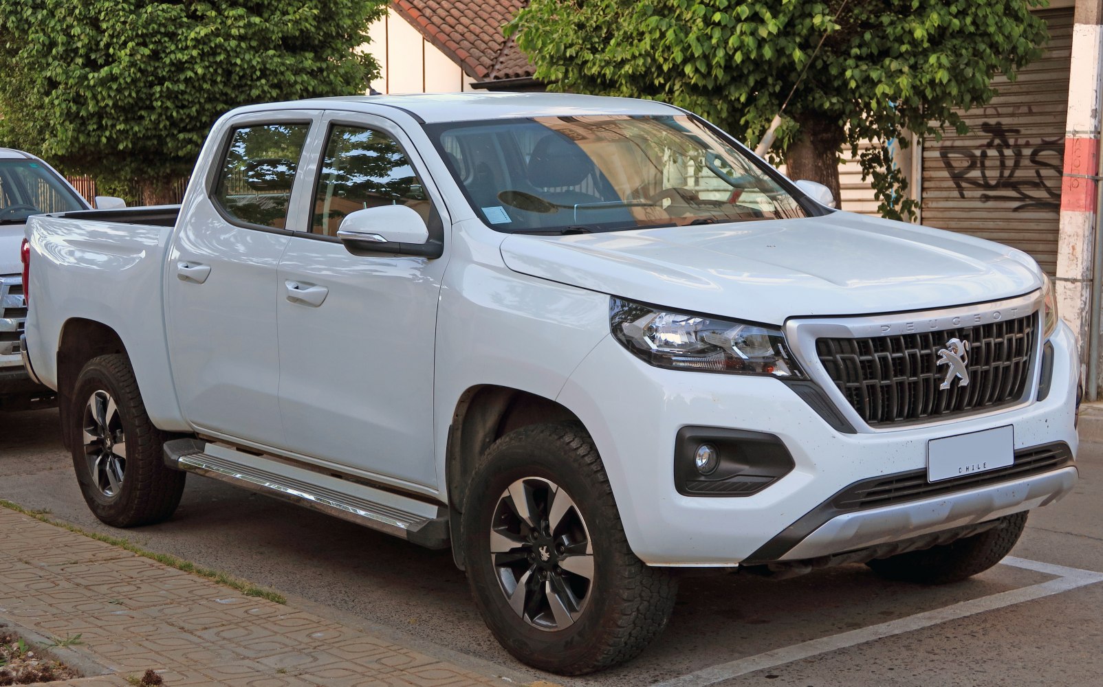 White double cab pickup truck with bold front grille and rugged design